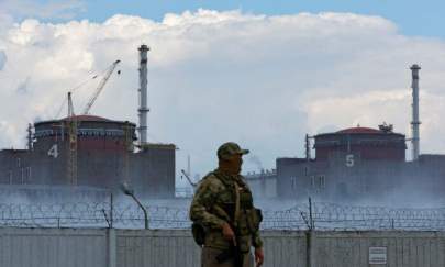 A serviceman with a Russian flag on his uniform stands guard near the Zaporizhzhia Nuclear Power Plant in the course of Ukraine-Russia conflict outside the Russian-controlled city of Enerhodar in the Zaporizhzhia region, Ukraine, on Aug. 4, 2022. (Alexander Ermochenko/Reuters)