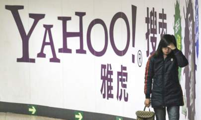 A woman walks past a Yahoo billboard in a subway in Beijing, China, on March 17, 2006. (AP Photo)