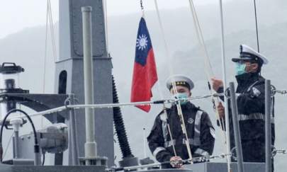 Two navy soldiers raise Taiwan's national flag during an official ceremony at a shipyard in Su'ao, a township in eastern Taiwan's Yilan County, on Dec. 15, 2020. (Sam Yeh/AFP via Getty Images)