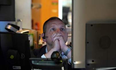 A person on the floor of the New York Stock Exchange (NYSE) watches TV screens on July 27, 2022. (Timothy A. Clary/AFP via Getty Images)