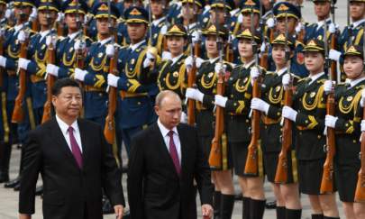 Russia's President Vladimir Putin (C) reviews a military honour guard with Chinese President Xi Jinping (L) during a welcoming ceremony outside the Great Hall of the People in Beijing on June 8, 2018. (Greg Baker/POOL/AFP via Getty Images)