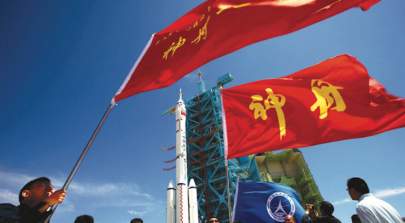 Chinese workers wave flags as the Shenzhou-9 spacecraft and its carrier rocket been move to the launch platform at the Jiuquan Satellite Launch Centre in northwest China. Credit: STR/AFP/GettyImages