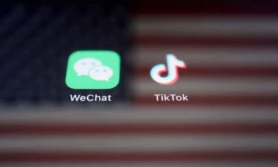 A reflection of the U.S. flag is seen on the signs of the WeChat and TikTok apps on Sept. 19, 2020. (Florence Lo/Reuters)