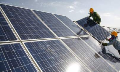 Workers install solar panels at a photovoltaic power station in Hami in northwestern China's Xinjiang Uyghur Autonomous Region Monday Aug. 22, 2011. (Chinatopix via AP)