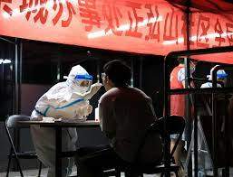 Medical worker collects a swab from a resident following new COVID-19 cases in Zhengzhou