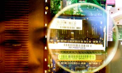 A woman looks through a magnifier to see a 2GB RAM from a notebook during the semi-tech show in Taipei 10 in May 2007. (Sam Yeh/AFP/Getty Images)