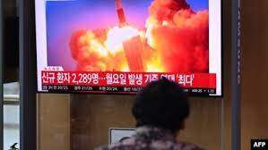 People watch a television news broadcast showing file footage of a North Korean missile test, at a railway station in Seoul on Sept. 28, 2021, after North Korea fired an "unidentified projectile" into the sea off its east coast, according to the South's military.
