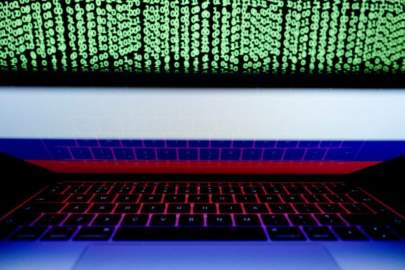 FILE PHOTO: A Russian flag is seen on the laptop screen in front of a computer screen on which cyber code is displayed, in this illustration picture taken March 2, 2018. REUTERS/Kacper Pempel/Illustration