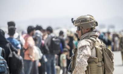 A Marine with Special Purpose Marine Air-Ground Task Force-Crisis Response-Central Command provides assistance during an evacuation at Hamid Karzai International Airport in Kabul, Afghanistan on Aug. 22, 2021. (Sgt. Samuel Ruiz/U.S. Marine Corps via AP)