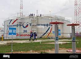  Workers walk past a storage tank at the Kaleikino oil pumping station of Transneft Kama Region, near Almetyevsk, Russia, April 27, 2022.